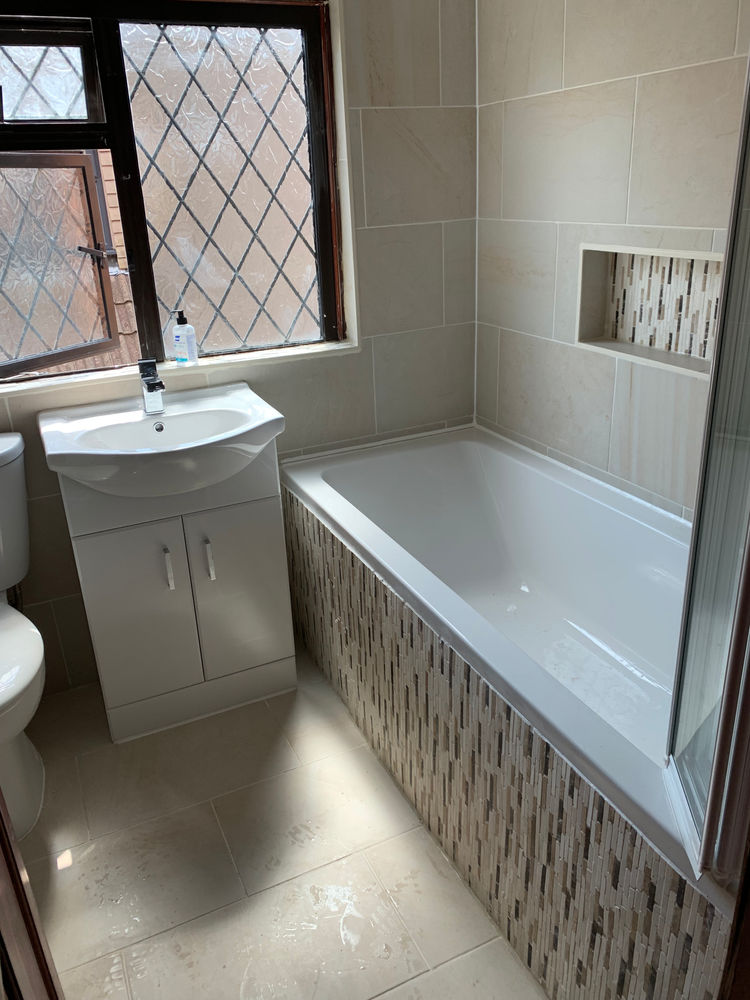 Completed bathroom with bath, basin and tiled walls
